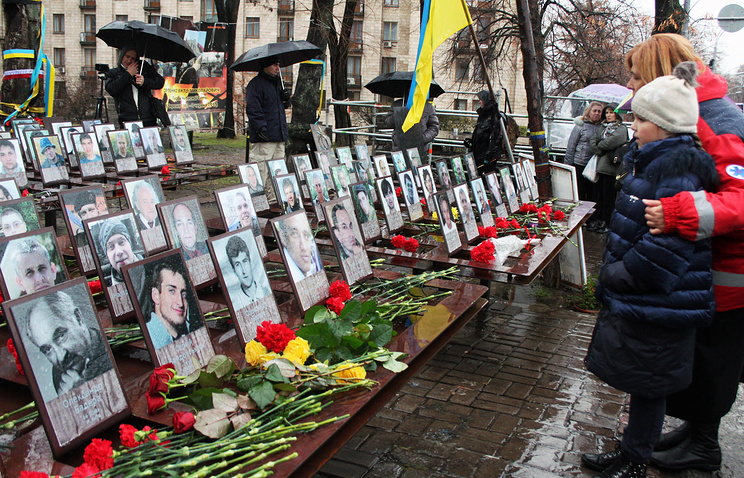 Kiev residents lay flowers at the Heavenly Hundred Memorial honoring those killed in the February 2014 clashes in Kiev's Independence Square 