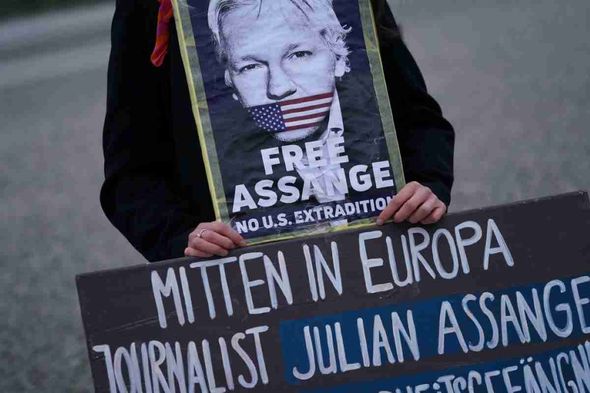 A demonstrator with a Julian Assange poster