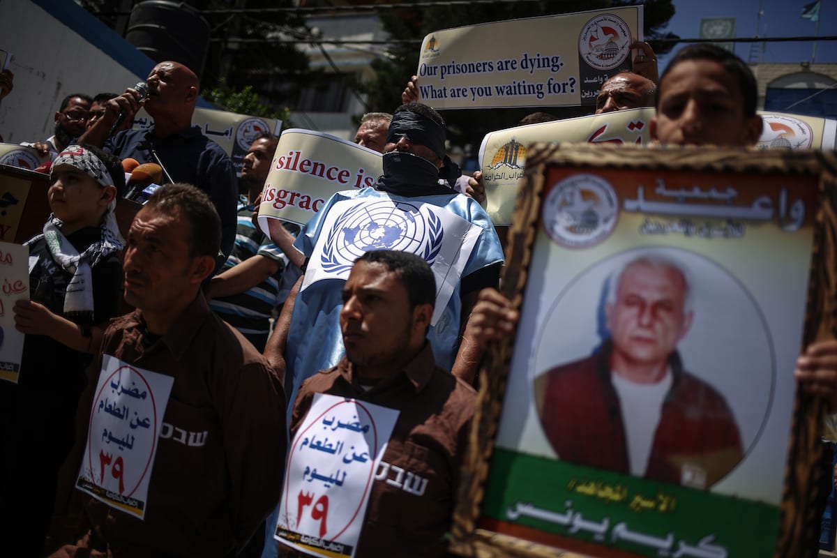 Palestinian demonstrators hold placards during a demonstration in support Palestinian prisoners held in Israeli jails in Gaza City, Gaza on May 25, 2017 [Ali Jadallah/Anadolu Agency]