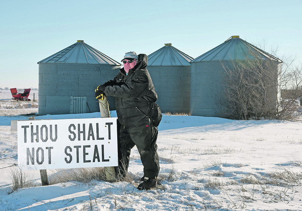 Miles Moore put this sign at the entrance to his farm near Outlook, Sask., after 1,800 bushels of canola — $40,000 worth — was stolen from one of his bins this January. Farmers are using technology from social media to security systems to detect and act upon suspicious behaviour. | William DeKay photo