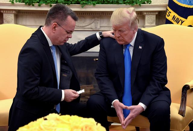 FILE PHOTO: U.S. President Donald Trump closes his eyes in prayer along with Pastor Andrew Brunson, after his release from two years of Turkish detention, in the Oval Office of the White House, Washington, U.S., October 13, 2018. REUTERS/Mike Theiler/File Photo