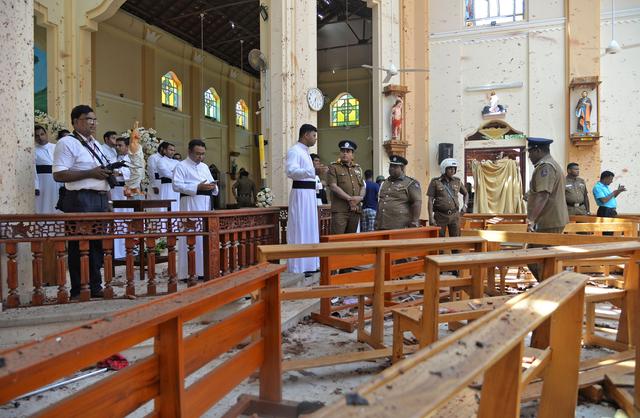 Police officials and catholic priests stand inside the church after a bomb blast in Negombo, Sri Lanka April 21, 2019. REUTERS/Stringer 