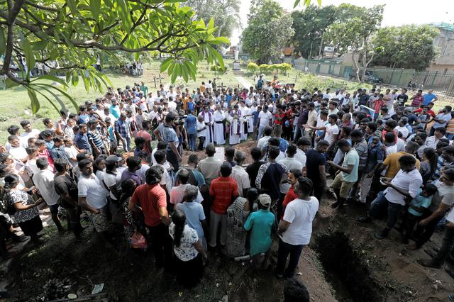 People attend a mass burial of victims, two days after a string of suicide bomb attacks on churches and luxury hotels across the island on Easter Sunday, in Colombo, Sri Lanka April 23, 2019. REUTERS/Dinuka Liyanawatte