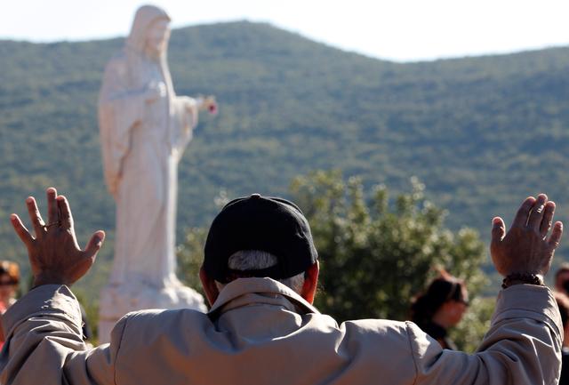 FILE PHOTO: A Catholic pilgrim prays at Podbrdo Hill, where the Virgin Mary reportedly appeared in an apparition in 1981, in Medjugorje, south of Sarajevo, October 8, 2010. REUTERS/ Matko Biljak/File Photo