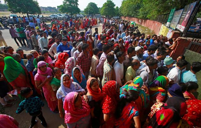 FILE PHOTO: Voters stand in queues as they wait to cast their vote outside a polling station during the final phase of general election in Chandigarh, India, May 19, 2019. REUTERS/Ajay Verma/File Photo