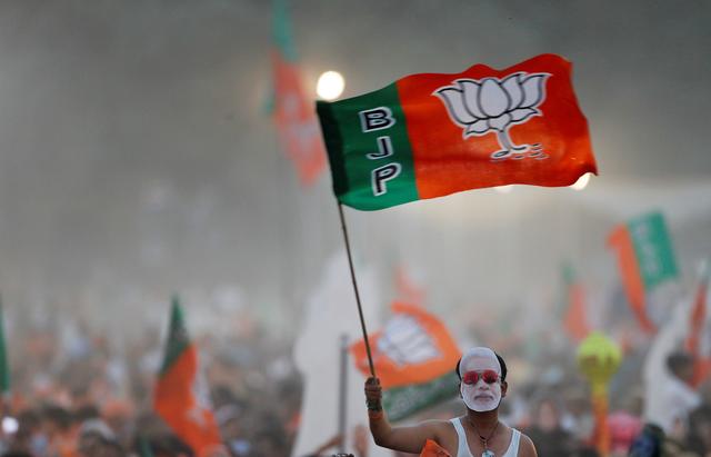 FILE PHOTO: A supporter of India's ruling Bharatiya Janata Party (BJP) waves the party flag during an election campaign rally being addressed by India's Prime Minister Narendra Modi in New Delhi, India, May 8, 2019. REUTERS/Adnan Abidi