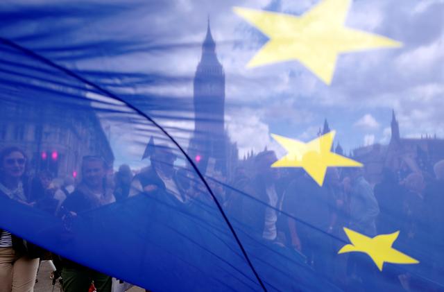 FILE PHOTO:  The Houses of Parliament are seen through a European Union flag as demonstrators arrive  in Parliament Square during the anti-Brexit 'People's March for Europe', in central London, Britain September 9, 2017.   REUTERS/Tolga Akmen