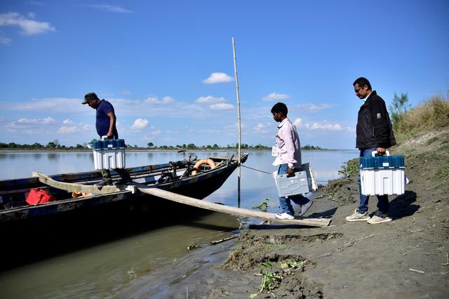 Election staff carrying Voter Verifiable Paper Audit Trail (VVPAT) machines and an Electronic Voting Machine (EVM) board a boat to reach remote polling stations at Lahori Chapori in Golaghat district in the northeastern state of Assam, India, April 10, 2019. REUTERS/Anuwar Hazarika