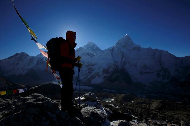 FILE PHOTO: A trekker stands in front of Mount Everest, which is 8,850 meters high (C), at Kala Patthar in Solukhumbu District May 7, 2014. REUTERS/Navesh Chitrakar/File Photo
