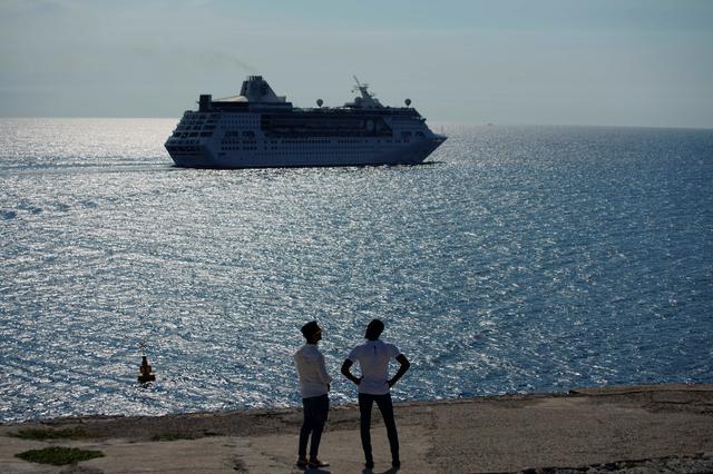 Men watch the cruise ship MS Empress of the Seas, operated by Royal Caribbean International, as it leaves the bay of Havana, Cuba, June 5, 2019. REUTERS/Alexandre Meneghini