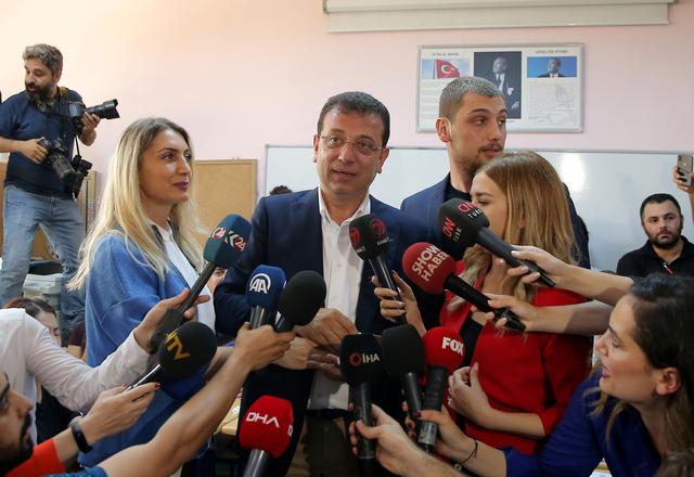 Ekrem Imamoglu, mayoral candidate of the main opposition Republican People's Party (CHP), speaks next to his wife Dilek and son Semih after casting their ballots at a polling station in Istanbul, Turkey, June 23, 2019. REUTERS/Huseyin Aldemir