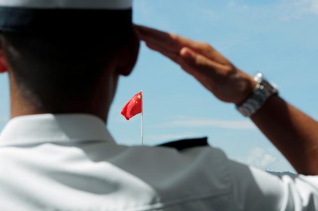 FILE PHOTO: A People's Liberation Army (PLA) soldier saluts to Chinese national flag during an open day of Stonecutters Island naval base, in Hong Kong, China, June 30, 2019. REUTERS/Tyrone Siu/File Photo