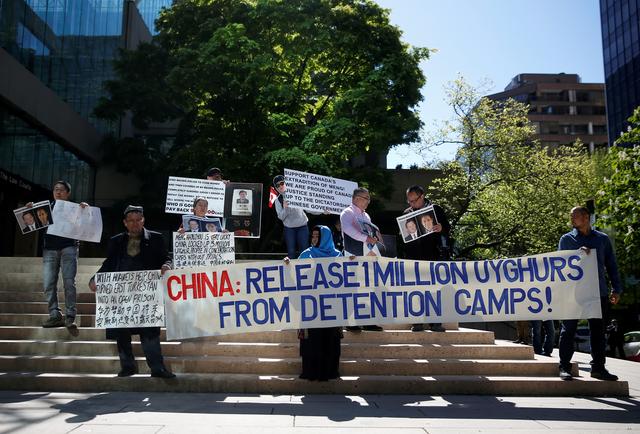 FILE PHOTO: People hold signs protesting China's treatment of the Uighur people, in Vancouver, British Columbia, Canada, May 8, 2019. REUTERS/Lindsey Wasson/File Photo