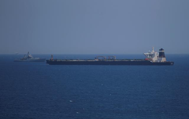 FILE PHOTO: A British Royal Navy patrol vessel guards the oil supertanker Grace 1, that's on suspicion of carrying Iranian crude oil to Syria, as it sits anchored in waters of the British overseas territory of Gibraltar, historically claimed by Spain, July 4, 2019. REUTERS/Jon Nazca/File Photo