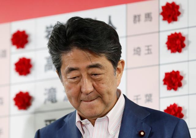 Japan's Prime Minister Shinzo Abe, who is also leader of the ruling Liberal Democratic Party (LDP), looks on as he puts a rosette on the name of a candidate who is expected to win the upper house election, at the LDP headquarters in Tokyo, Japan, July 21, 2019. REUTERS/Kim Kyung-Hoon