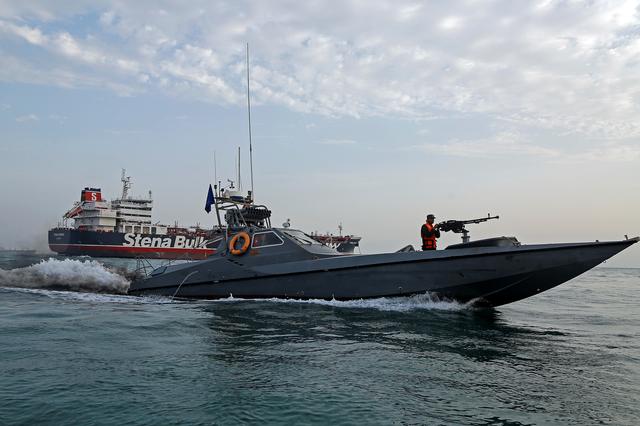A boat of the Iranian Revolutionary Guard sails next to Stena Impero, a British-flagged vessel owned by Stena Bulk, at Bandar Abbas port, July 21, 2019. Iran, Mizan News Agency/WANA Handout via REUTERS