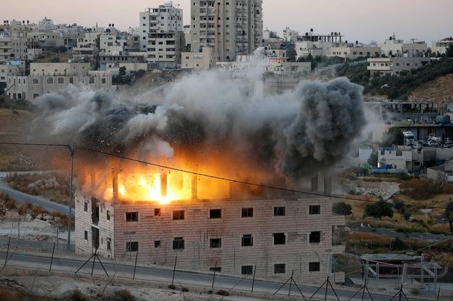 A Palestinian building is blown up by Israeli forces in the village of Sur Baher which sits on either side of the Israeli barrier in East Jerusalem and the Israeli-occupied West Bank July 22, 2019. REUTERS/Mussa Qawasma