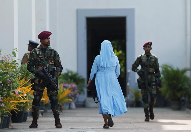 FILE PHOTO: A nun arrives as a Sri Lanka's commando soldier stands guard in front of the main entrance to St. Lucia Cathedral as survivors and families of victims of Sri Lanka's Easter Sunday bombing arrive for a special mass for those who lost their lives, in Colombo, Sri Lanka May 11, 2019. REUTERS/Dinuka Liyanawatte