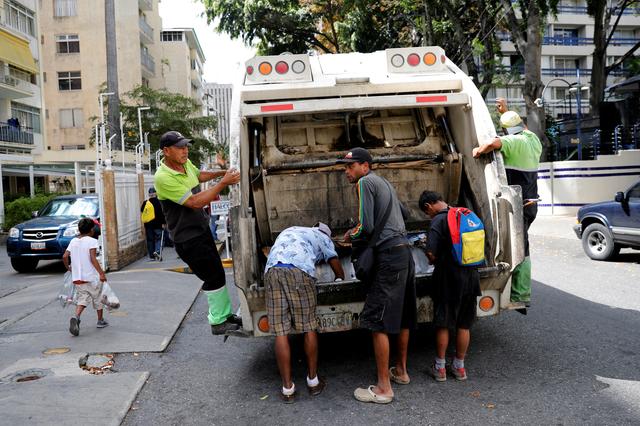 FILE PHOTO: Children scavenge for food in a rubbish truck in Caracas, Venezuela February 27, 2019. REUTERS/Carlos Jasso/File Photo