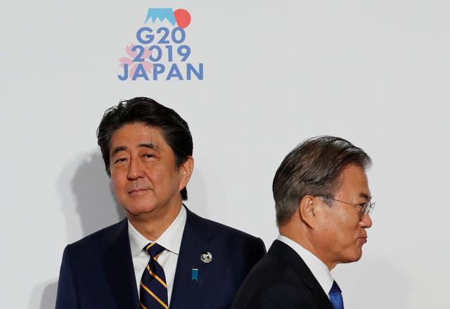 FILE PHOTO:  South Korean President Moon Jae-In is welcomed by Japanese Prime Minister Shinzo Abe upon his arrival for a welcome and family photo session at G20 leaders summit in Osaka, Japan, June 28, 2019. REUTERS/Kim Kyung-Hoon/Pool