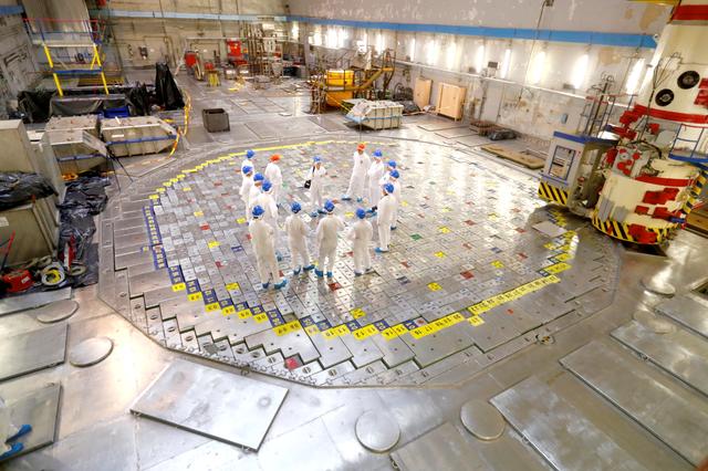 People stand on top of a dismantled nuclear reactor during a guided tour to decommissioned Ignalina nuclear power station in Visaginas, Lithuania July 24, 2019. Picture taken July 24, 2019. REUTERS/Ints Kalnins