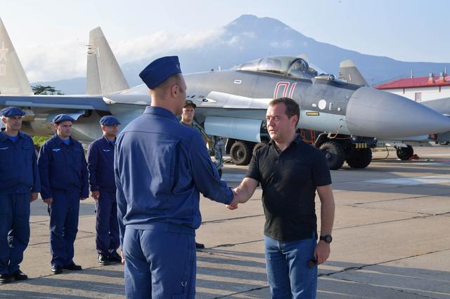 Russian Prime Minister Dmitry Medvedev shakes hands with Air Force officer at the Yasny airport during visits the Southern Kuril Island of Iturup, Russia August 2, 2019.  Sputnik/Alexander Astafyev/Pool via REUTERS 