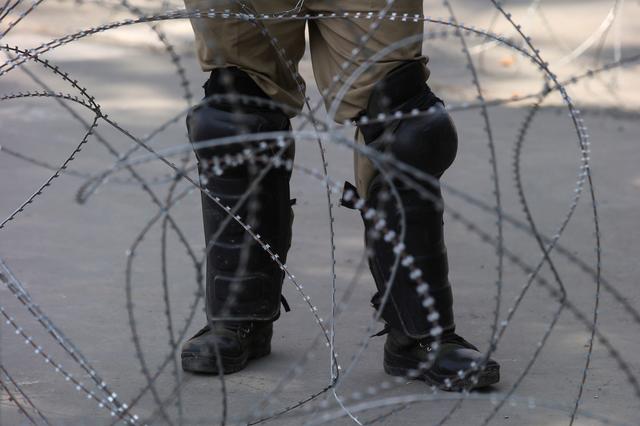 FILE PHOTO: An Indian police officer stands behind the concertina wire during restrictions on Eid-al-Adha after the scrapping of the special constitutional status for Kashmir by the Indian government, in Srinagar, August 12, 2019. REUTERS/Danish Ismail