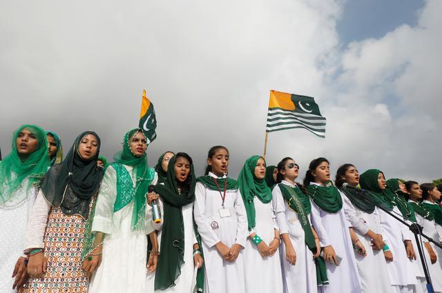 Attendees perform Pakistan's national anthem with Kashmir's flag, to express solidarity with the people of Kashmir, during a ceremony to celebrate Pakistan's 72nd Independence Day at the Mausoleum of Muhammad Ali Jinnah in Karachi, Pakistan August 14, 2019. REUTERS/Akhtar Soomro