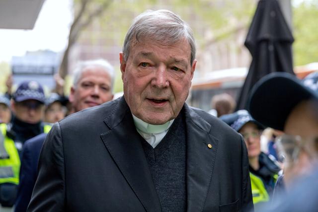 FILE PHOTO: Vatican Treasurer Cardinal George Pell is surrounded by Australian police as he leaves the Melbourne Magistrates Court in Australia, October 6, 2017.    REUTERS/Mark Dadswell