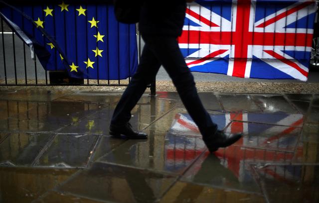 FILE PHOTO: A person walks past an EU and a British flag in London, Britain, April 2, 2019. REUTERS/Hannah Mckay