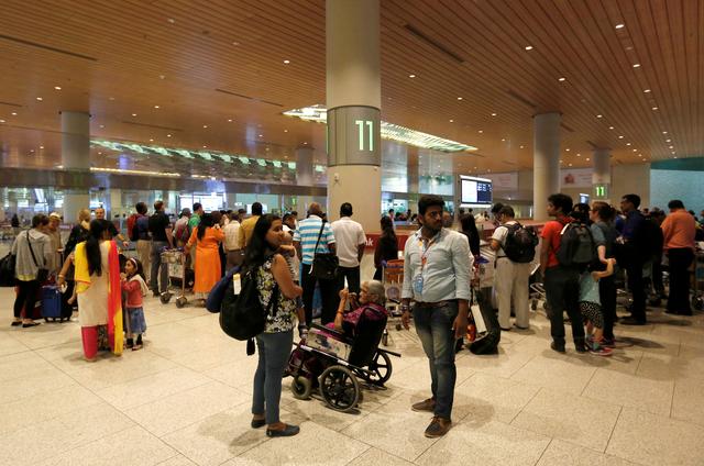 FILE PHOTO: Passengers wait for their luggage at a conveyor belt at the Chhatrapati Shivaji International airport in Mumbai, India, February 7, 2017.  REUTERS/Danish Siddiqui/File Photo