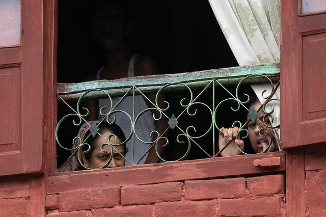 Kashmiri residents look out of their house during restrictions after the scrapping of the special constitutional status for Kashmir by the government, in Srinagar, August 14, 2019. REUTERS/Danish Siddiqui