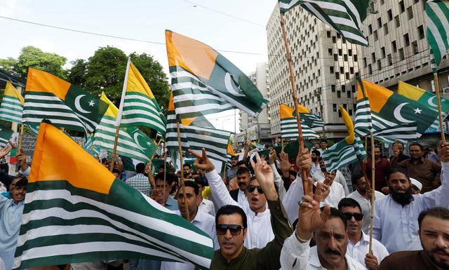 People carry Azad Kashmir's flags and chant slogans over India's decision to revoke the special status of Jammu and Kashmir, during a protest in Karachi, Pakistan August 18, 2019. REUTERS/Akhtar Soomro