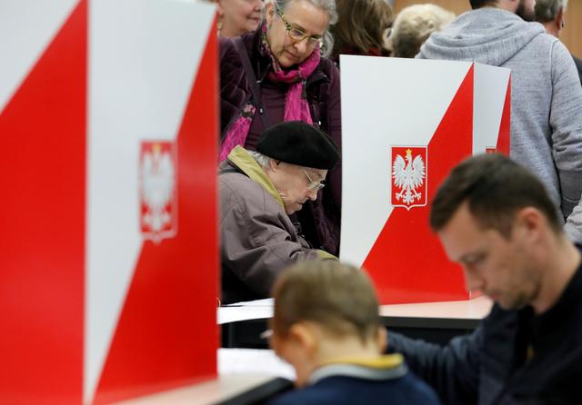 FILE PHOTO: People attend the Polish regional elections, at a polling station in Warsaw, Poland, October 21, 2018. REUTERS/Kacper Pempel