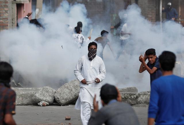 Kashmiris run for cover as smoke rises from teargas shells fired by Indian security forces during clashes, after scrapping of the special constitutional status for Kashmir by the Indian government, in Srinagar, August 23, 2019. REUTERS/Adnan Abidi