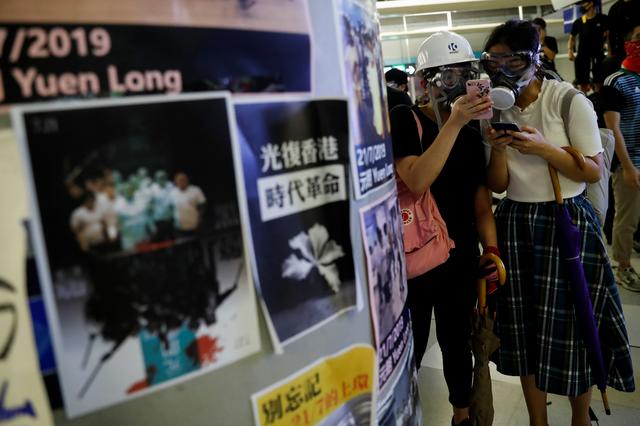FILE PHOTO: Protesters check their phones as they take part in a protest inside the Yuen Long MTR station, the scene of an attack by suspected triad gang members a month ago, in Yuen Long, New Territories, Hong Kong, China August 21, 2019. REUTERS/Tyrone Siu