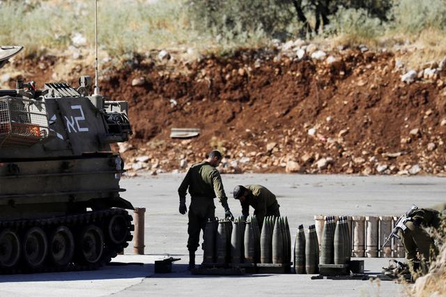 FILE PHOTO: Israeli soldiers stand next to shells and a mobile artillery unit near the Israeli side of the border with Syria in the Israeli-occupied Golan Heights August 26, 2019. REUTERS/Amir Cohen/File Photo