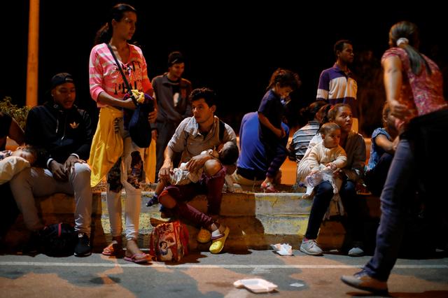 FILE PHOTO: Venezuelan migrants wait outside the Ecuadorian-Peruvian border service center, to process their documents and be able to continue their journey, on the outskirts of Tumbes, Peru June 15, 2019.  REUTERS/Carlos Garcia Rawlins