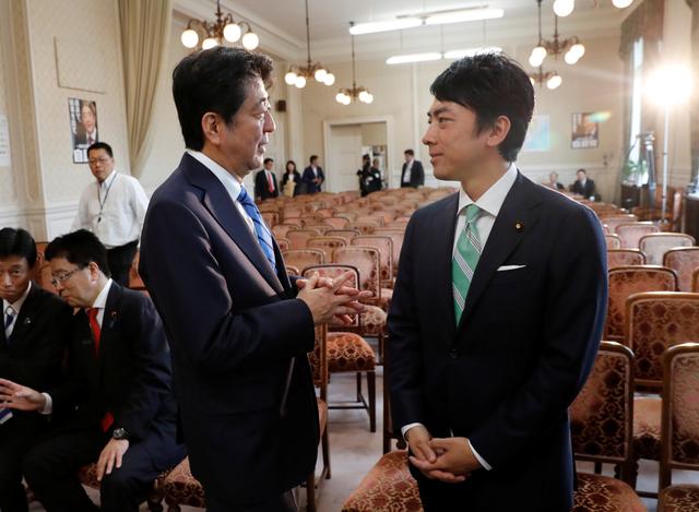 FILE PHOTO - Japan's Prime Minister Shinzo Abe (L) talks with his party's lawmaker Shinjiro Koizumi, son of former Prime Minister Junichiro Koizumi, at the party lawmakers' meeting after the dissolution of the lower house was announced at the Parliament in Tokyo, Japan September 28, 2017.  REUTERS/Kim Kyung-Hoon