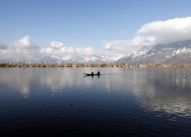 A man rows a small boat on the waters of Dal Lake on a sunny day in Srinagar February 4, 2015. REUTERS/Danish Ismail