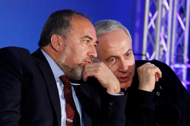 FILE PHOTO: Israel's Prime Minister Benjamin Netanyahu (R) converses with former Foreign Minister Avigdor Lieberman during a Likud-Yisrael Beitenu campaign rally in the southern Israeli city of Ashdod January 16, 2013. REUTERS/Amir Cohen/File Photo
