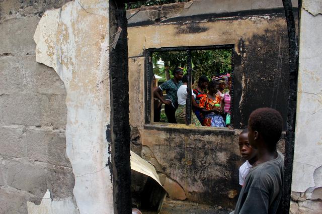 People walk through a burned building after a fire swept through a school killing children in Monrovia, Liberia September 18, 2019.    REUTERS/Stringer 