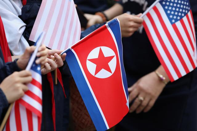 Bystanders holding North Korea and U.S. flags wait for the motorcade of U.S. President Donald Trump in Hanoi, Vietnam, February 27, 2019. REUTERS/Ann Wang