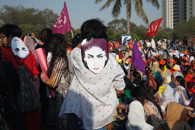 FILE PHOTO: People wear masks depicting Qandeel Baloch, social media celebrity, who according to the police was strangled in what appeared to be an honour killing in 2016, as they take part in an Aurat March, or Women's March in Karachi, Pakistan March 8, 2018. REUTERS/Akhtar Soomro