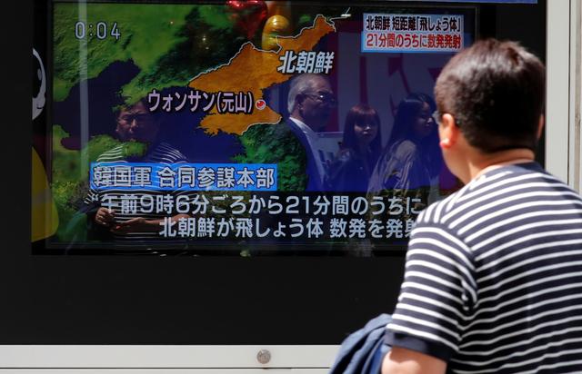 FILE PHOTO: A man watches a television screen showing a news report on North Korea firing several short-range projectiles from its east coast, on a street in Tokyo, Japan May 4, 2019. REUTERS/Kim Kyung-Hoon/File Photo