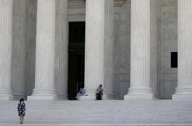 FILE PHOTO: People are pictured on the stairs outside of the U.S. Supreme Court in Washington, D.C., U.S., June 17, 2019. REUTERS/Leah Millis/File Photo