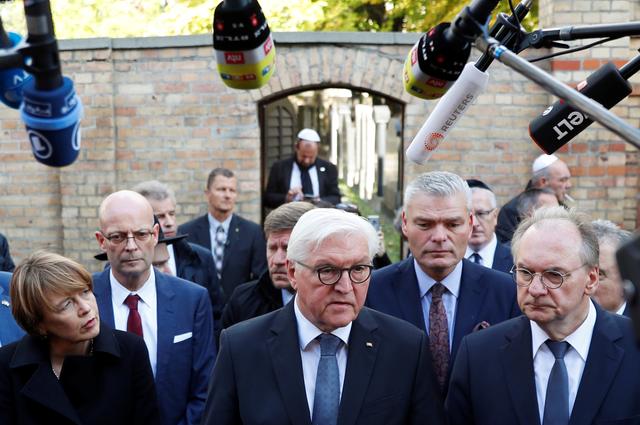 German President Frank-Walter Steinmeier speaks to the media next to his wife Elke Budenbender and Saxony-Anhalt State Premier Reiner Haseloff outside the synagogue in Halle, Germany October 10, 2019, after two people were killed in a shooting.  REUTERS/Fabrizio Bensch