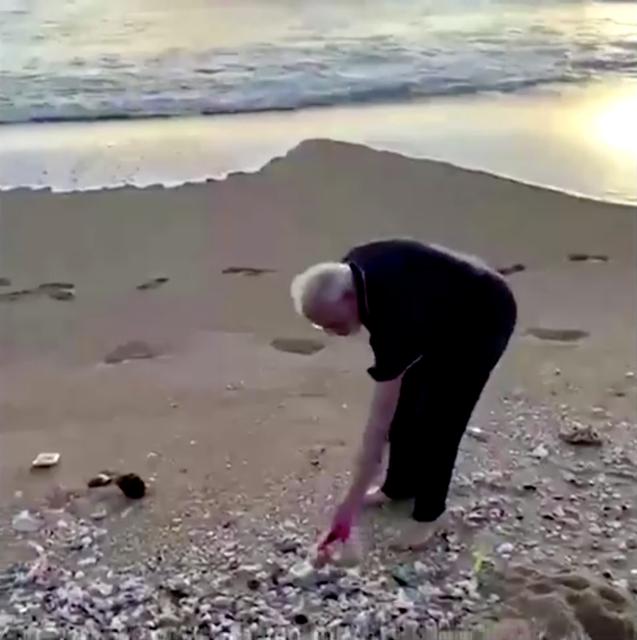 India's Prime Minister Narendra Modi picks up plastic trash at the beach ahead of talks with China's President President Xi Jinping in Mamallapuram, India October 12, 2019 in this still image obtained from video. Narendra Modi/Reuters TV via REUTERS 