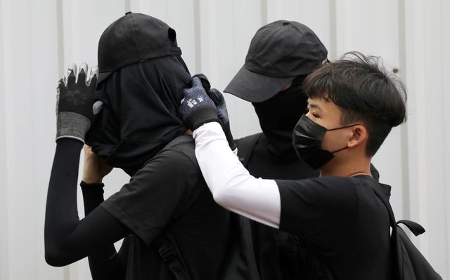 FILE PHOTO: Anti-government protesters adjust their masks during a protest at Wong Tai Sin district, in Hong Kong, China, October 13, 2019. REUTERS/Athit Perawongmetha/File Photo