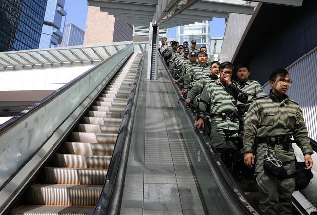 Police officers stand guard on an escalator ahead of Hong Kong Chief Executive Carrie Lam's annual policy address, after four months of anti-government protests, at the Legislative Council in Hong Kong, China, October  16, 2019. REUTERS/Ammar Awad - RC1EDF103290